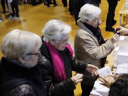 Tres hermanas ancianas acuden juntas a votar en la Escola Pere IV de Barcelona, ayer.