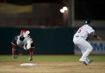 Chris Roberson (izquierda) de los Yanquis de Obregón de México salta a la base, en el partido contra los Leones del Escogido de República Dominicana.