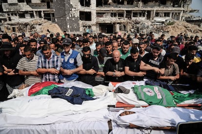 CORRECTS SURNAME TO QREIQEH, INSTEAD OF QUREIQA - Palestinians pray over the bodies of journalists, including Al Jazeera correspondents Anas al-Sharif and Mohamed Qreiqeh, who were killed in an Israeli airstrike, during their funeral outside Gaza City's Shifa hospital complex, Monday, Aug. 11, 2025. (AP Photo/Jehad Alshrafi)