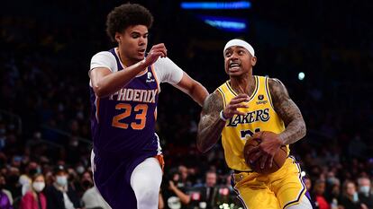 Isaiah Thomas, de los Laker, penetra a canasta pese a la oposición de Cameron Jordan, jugador de Phoenix Suns en el partido que disputaron el 21 de diciembre.