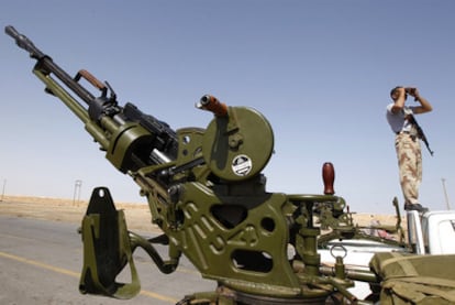 Un guerrillero rebelde otea el horizonte junto a un antiaéreo a la entrada de Ajdabiya, al este de Libia