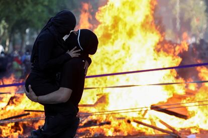 Una pareja se besa en el medio del incendio ocasionado por una de las barricadas.