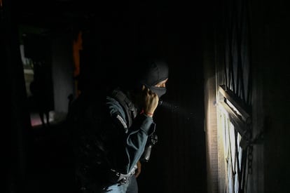 A police officer uses his flashlight during an investigative operation in San José, in August 2023.