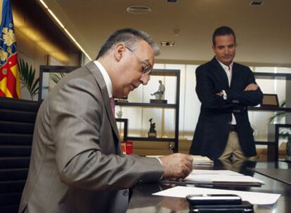 Agustín Navarro, alcalde de Benidorm, firma documentos en su despacho bajo la mirada del tránsfuga José Bañuls.