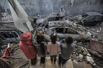 Niños palestinos observan las viviendas y vehículos destruidos por un bombardeo israelí, este miércoles en Rafah, al sur de la Franja. 