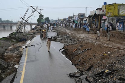 Un grupo de personas junto a una carretera dañada en una zona afectada por el terremoto a las afueras de Mirpur (Pakistán), que ha causado la muerte de 22 personas y cientos de heridos.