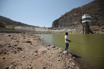 Un trabajador pesca en la represa Miguel Alemán de Valle de Bravo, en 2024.