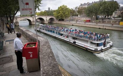 Un usuario en acción en uno de los polémicos urinarios callejeros de parís, en los muelles de la Île Saint-Louis.