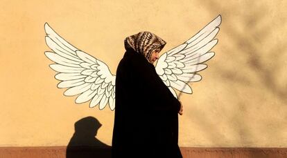 Una mujer en Teher&aacute;n frente a una pintada.