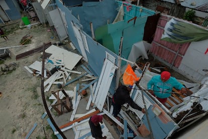 El huracán 'Fiona' ha dejado estragos este lunes a su paso por República Dominicana. En la imagen, residentes del municipio de Verón, en Punta Cana, sustituyen el techo de una casa que fue arrancado por los fuertes vientos que trajo el ciclón, durante la tarde del 19 de septiembre de 2022.