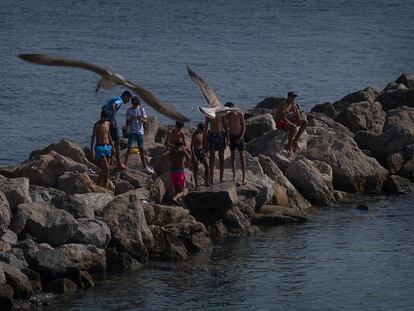 Menores marroquíes que llegaron a Ceuta en el cruce masivo de mayo de 2021, en un espigón de la playa de La Ribera, en la ciudad autónoma, el miércoles.