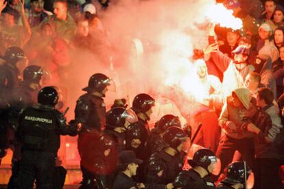 La policía intenta contener a varios aficionados con bengalas ayer, durante el Serbia-Bosnia.