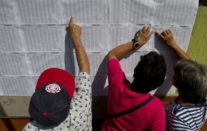 Ciudadanos colombianos buscan sus nombres a las afueras de un colegio electoral en Cali.