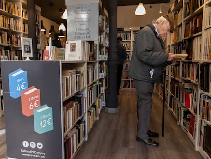 Un hombre hojea un libro en la librería de segunda mano Re-Read de Martínez Campos, Madrid.