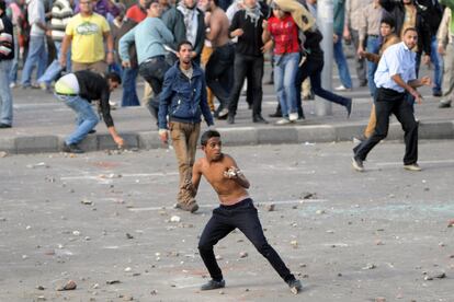 Un joven lanza piedras durante una manifestación entre partidarios y detractores del presidente Morsi en Alejandría.