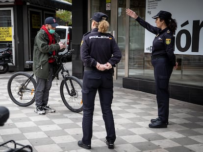 Agentes de la Policia Nacional informan a un usuario en bicicleta en el centro de Granada.