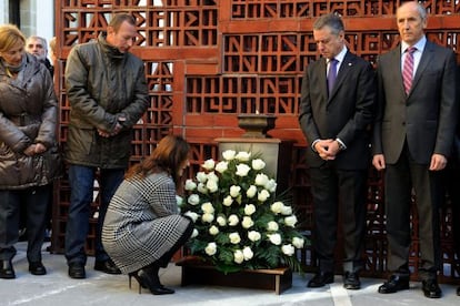 La presidenta del Parlamento vasco ajusta la ofrenda floral en presencia del resto de asistentes.