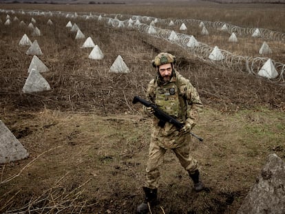 Ukrainian military engineer with the call sign "Lizard" walks near fortifications, including "dragon's teeth" and barbed wire, that he helped to build in a field near the front line outside Kupiansk, amid Russia’s attack on Ukraine, December 28, 2023.  REUTERS/Thomas Peter     TPX IMAGES OF THE DAY