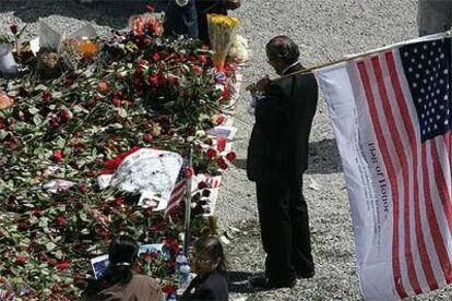 Un hombre sostiene una bandera de Estados Unidos durante la ceremonia celebrada ayer en la <i>zona cero </i>de Nueva York.