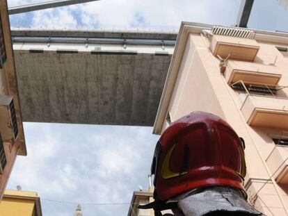 Un bombero observa los edificios evacuados bajo los restos del puente Morandi, en Génova.