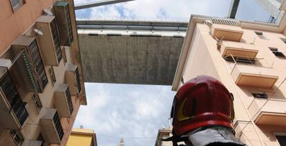 Un bombero observa los edificios evacuados bajo los restos del puente Morandi, en Génova.