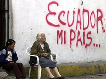 Una anciana y una niña, junto a una pintada en Quito.