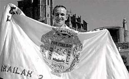 José Luis Korta posa con la bandera de la Concha junto al puerto de Castro.