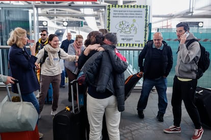 Varios pasajeros se abrazan en la estación Joaquín Sorolla de Valencia.