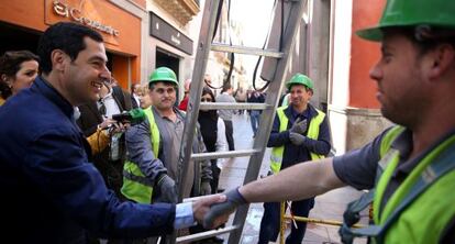 Juan Manuel Moreno saluda a trabajadores en la calle Sierpes de Sevilla.