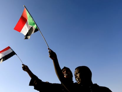 Unos jóvenes ondean la bandera sudanesa en la Plaza de la Libertad durante el primer aniversario del inicio del levantamiento que derrocó al antiguo gobernante Omar al-Bashir, en Jartum, Sudán, el 19 de diciembre de 2019.