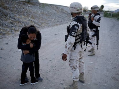 Lety Perez, inmigrante guatemalteca, abaraza a su hijo ante los guardias fronterizos de México en Ciudad Juarez.