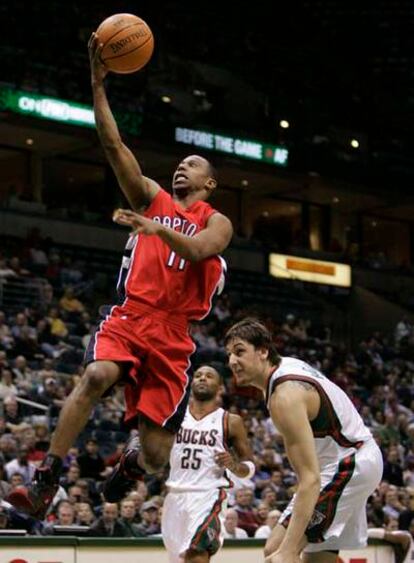 El base de los Raptors T.J.Ford entra a canasta ante la mirada del jugador de los Bucks Andrew Bogut.