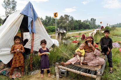 Una mujer con sus hijos se refugia a lo largo de una carretera después de huir de sus casas, en la provincia de Khyber Pakhtunkhwa, el sábado 27. Desde el principio de la temporada de lluvias, el 14 de junio, 982 personas han muerto (de las que 316 son niños), más de 3.000 kilómetros de carreteras y más de 680.000 viviendas se han visto afectadas, según datos de la Autoridad Nacional de Gestión de Desastres.