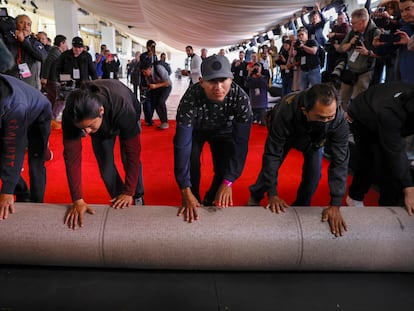 Varios trabajadores desenrollan la alfombra roja de los 96º premios Oscar, el miércoles 6 de marzo de 2024 junto al teatro Dolby, en Hollywood Boulevard, Los Ángeles.