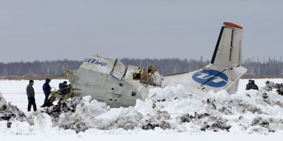 Miembros del equipo de rescate junto al avi&oacute;n siniestrado.