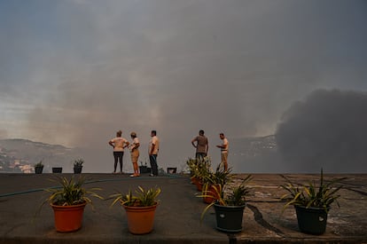 Varios residentes de la zona observan el incendio en el municipio de Baiao, Portugal, el lunes.