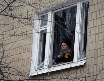 Una mujer retira trozos de cristales tras el bombardeo en Kramatorsk (Ucrania).