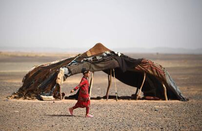 Una niña marroquí camina frente a una tienda durante la quinta etapa de la carrera, en Merzouga, el 3 de mayo de 2018.