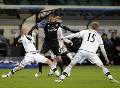 Karim Benzema (centro) en flanqueado por los jugadores del Legia.