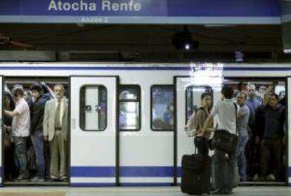 Algunos viajeros intentan acceder a los vagones repletos en la estación de Atocha-Renfe. EFE/Archivo