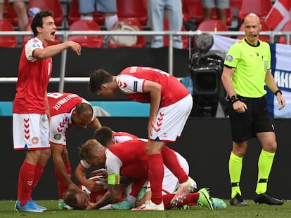 Los jugadores de Dinamarca atienden a Eriksen sobre el césped, el 12 de junio en Copenhague (Dinamarca).