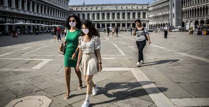 Dos mujeres pasean por la plaza de San Marcos en Venecia (Italia).