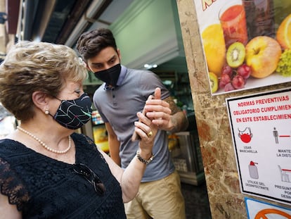 Personal de una cafetería de Santa Cruz de Tenerife comprueba el certificado de vacunación de una clienta.