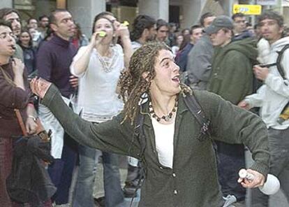 Jóvenes estudiantes lanzaron ayer huevos contra la sede del PP en Granada como protesta por la guerra en Irak.