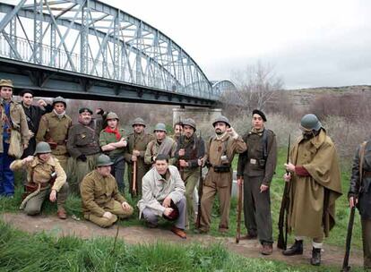 Miembros de una asociación para la recuperación de la memoria histórica posan vestidos de época para evocar una foto (abajo) tomada hace 70 años.