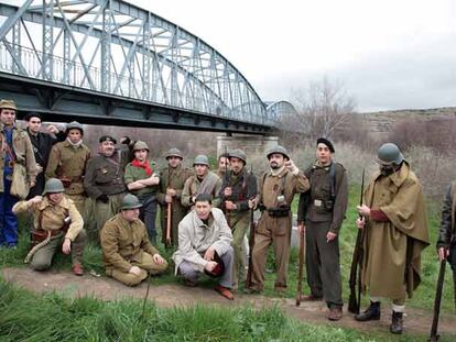 Miembros de una asociación para la recuperación de la memoria histórica posan vestidos de época para evocar una foto (abajo) tomada hace 70 años.