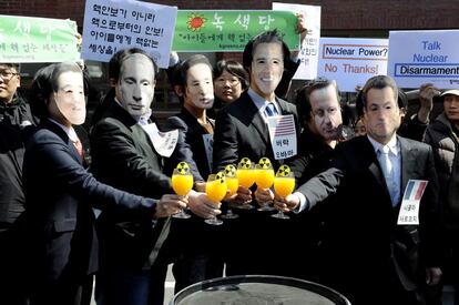 Activistas usan máscaras con los rostros de varios presidentes que participan en la segunda cumbre nuclear en Seúl (Corea del Sur).