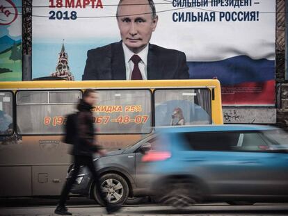 Un hombre pasa delante de un afiche electoral en favor de la candidatura del presidente de Rusia, Vlad&iacute;mir Putin, &quot;&iexcl;Un presidente fuerte, una Rusia fuerte!&quot;, en Crimea. 