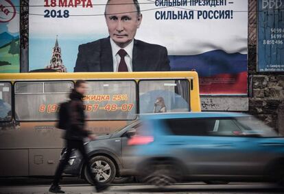 Un hombre pasa delante de un afiche electoral en favor de la candidatura del presidente de Rusia, Vladímir Putin, "¡Un presidente fuerte, una Rusia fuerte!", en Crimea.