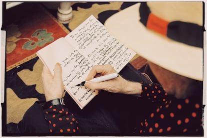 Sabina garabatea versos y canciones en un cuaderno.